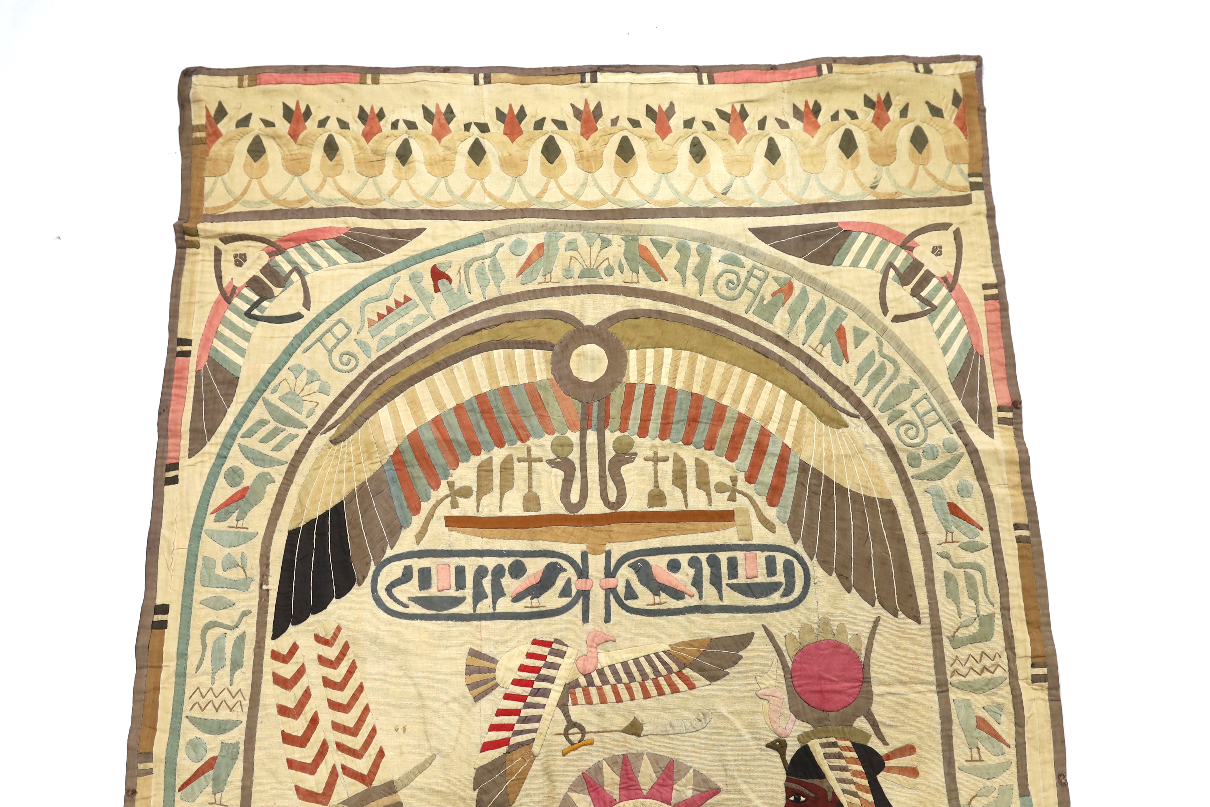 A 1930’s large Egyptian appliqué wall hanging, depicting Wadjet, (Goddess and protector of Kings) and Amun (God of wind) surrounded by hieroglyphic decorative symbols, 134cm wide x 268cm long